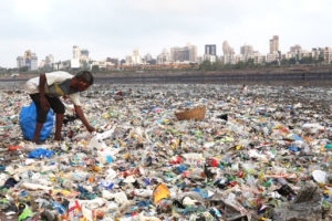 A “ragpicker” on Mumbai’s shoreline, which is littered with plastic waste.
  