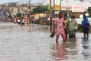 Residents wade through a road in the flooded Aboru neighborhood of Lagos, Nigeria in July.