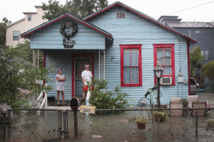 Residents of the Cottage Grove neighborhood in Houston, Texas watch as floodwaters surround their house in August 2017.