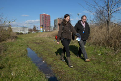City planner Leah Kacanda and Bryan Lennon, of Wilmington's  Water Division, walk into a wetlands area that will soon be part of a new park and natural flood mitigation project.