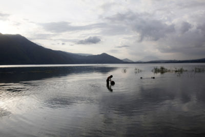 A boy collects water for his family on the shores of Samosir, an island in Lake Toba.