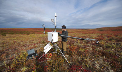 Branden Walker, a researcher from Wilfrid Laurier University, gathers data from a weather station on the tundra in the Northwest Territories.