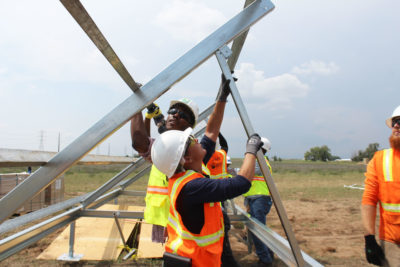 Workers receive job training while building a shared solar farm in Platteville, Colorado.