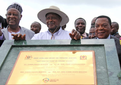 Uganda's President Yoweri Museveni, (center), with Tanzania's Minister of Foreign Affairs Augustine Mahiga (right), during a ceremony to lay the foundation stone for the East African Crude Oil Pipeline in 2017.