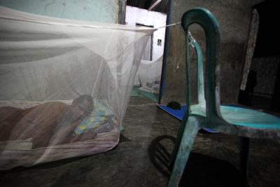 A man sleeps inside a mosquito net in his home in West Papua, Indonesia.