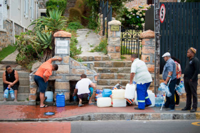 People wait to collect water from a natural spring in the Cape Town suburb of St. James in January 2018.