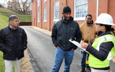 Solar contractor Brad Boston (center) and utility representatives meet with engineer Pranay Kohli to discuss a community solar project at DuPont Park Seventh Day Adventist Church in Washington, D.C.