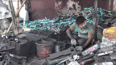 A worker dismantles toner cartridges in Guiyu, China.