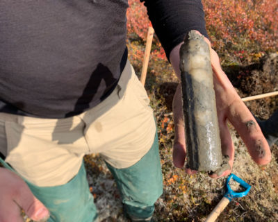 Researchers Evan Wilcox [left] and Niels Weiss extract ice-rich permafrost cores [as seen in photo, right] from the tundra.