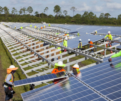 Workers install panels last year at the Babcock Solar Energy project in Punta Gorda, Florida. The project is one of eight new utility-scale solar farms in the state set to be completed by early 2018. 