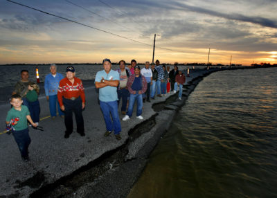 Chief Albert Naquin (with arms folded) and members of his tribe of Biloxi-Chitimacha Choctaw Indians on the Isle de Jean Charles lake road, which has eroded to one lane, in November 2008.