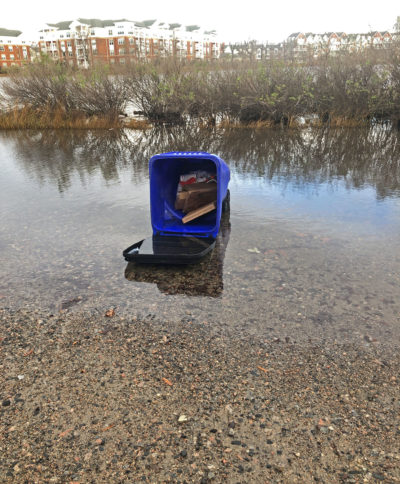 An overturned trash can sits in high-tide floodwaters on 52nd Street in Norfolk, Virginia.