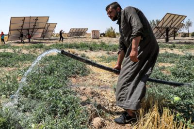 Farmer Mohamed Ali al-Hussein waters a watermelon patch near Hasakeh, Syria with the help of a solar-powered pump.

