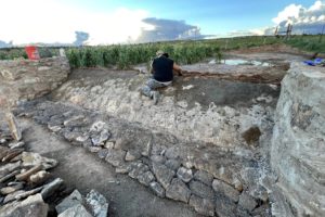 Danielle Kaye builds a berm spillway on the farm of Roberto Nutlouis. The berm holds back water, flooding the cornfield behind it.