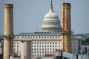 The U.S. Capitol, flanked by the stacks of the Capitol Power Plant, a fossil fuel-burning power plant.