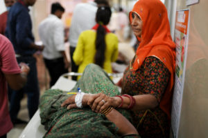 A woman comforts a relative suffering from heat stroke in Varanasi, India, May 30, 2024.

