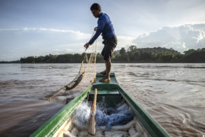 A fisher hauls in his net on the Mekong River at the height of monsoon season last August.