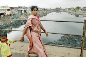 A woman and her son cross the Mithi River in Mumbai.