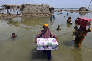 Women and children evacuate their flooded homes in Sindh Province, Pakistan on September 6, 2022.