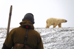 A Russian ranger monitors a polar bear during a collaborative research effort on Russia's Wrangel Island in 2019.