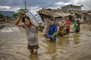 Residents of Rodriguez, in the Philippines, wade through floodwaters left by Typhoon Vamco in November 2020.