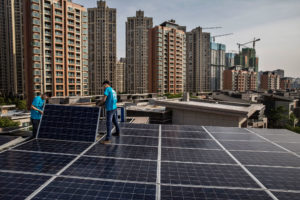 Workers install rooftop solar in the Chinese city of Wuhan, which has joined with cities across the globe to fight climate change.