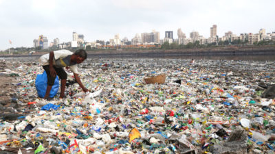 A “ragpicker” on Mumbai’s shoreline, which is littered with plastic waste.
  