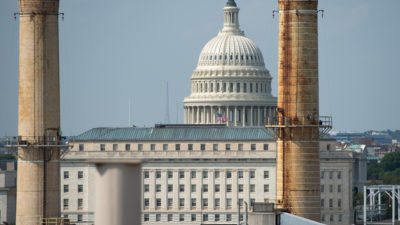 The U.S. Capitol, flanked by the stacks of the Capitol Power Plant, a fossil fuel-burning power plant.