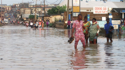 Residents wade through a road in the flooded Aboru neighborhood of Lagos, Nigeria in July.