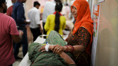 A woman comforts a relative suffering from heat stroke in Varanasi, India, May 30, 2024.

