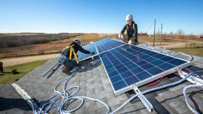 Former tar sands workers install solar panels on a childcare center near Wetaskiwin, Alberta.