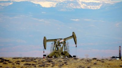 An oil pump on federal lands in northeastern Utah, with the Uinta Mountains in the background.