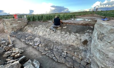 Danielle Kaye builds a berm spillway on the farm of Roberto Nutlouis. The berm holds back water, flooding the cornfield behind it.