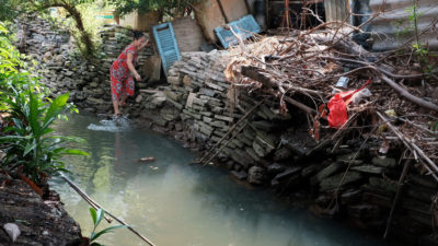 A woman who identified herself as Mrs. Mai washes her feet in the dioxin-laden Buu Long canal. 