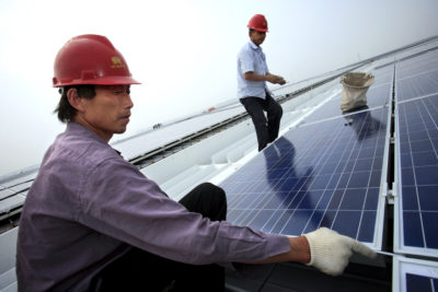 Workers install solar panels on the Hongqiao train station in Shanghai.