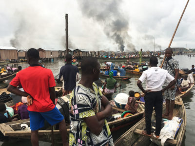 Evicted residents of the Otodo Gbame settlement in Lagos, Nigeria watch smoke from homes burned by authorities in 2017.