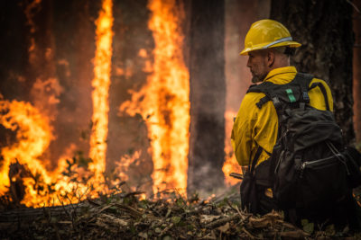 A firefighter confronts a blaze near Galice, Oregon.