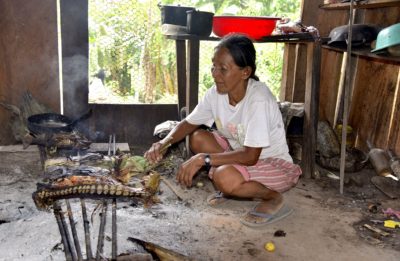 An Indigenous Chiman woman who lives along the Beni River cooks fish.

