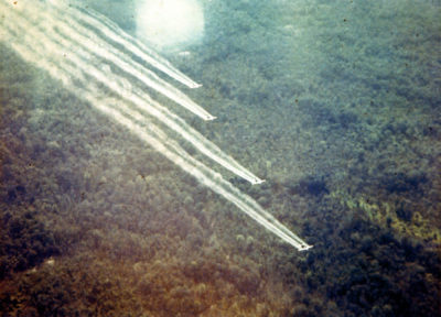 American C-123 aircraft releasing the defoliant Agent Orange over an area of forest in Vietnam in the 1960s.
