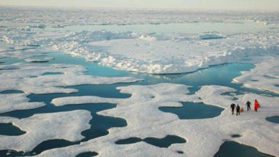 Scientists explore an area of sea ice and meltwater in the Arctic Ocean in July 2005.