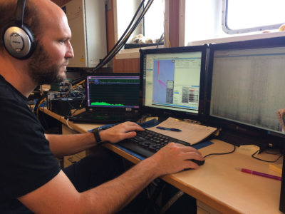 Lead author Brian Miller listens for the sound of an Antarctic blue whale.