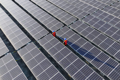 Workers inspect a rooftop solar array in Fuzhou, China.