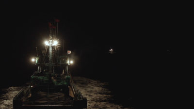 A Chinese squid vessel flying the South Korean flag while fishing at night.