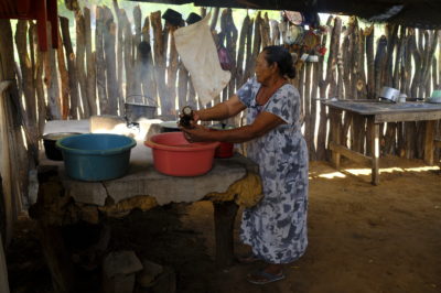 A woman prepares a meal in a traditional Wayúu home.