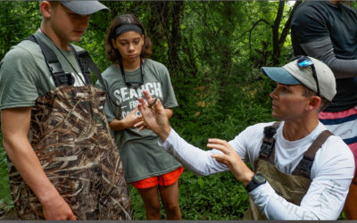 Dave Keller shows a crayfish to Andrew Coleman and Bella Morton, both 13.