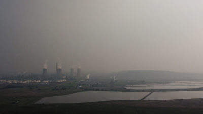 Smog surrounds the Sasol Synfuels plant in Secunda. Right: an aerial view of acidic water flowing from a coal mine in eMalahleni, Mpumalanga province in September.