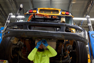 A technician converts a conventional school bus to an electric school bus at a facility in Holbrook, New York, March 2023.