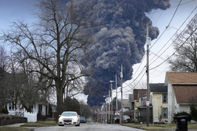 Smoke rises from a train derailment in East Palestine, Ohio, that spilled 115,000 gallons of vinyl chloride last February.