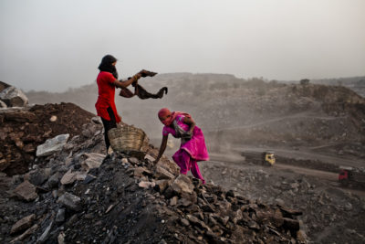 Young women scavenge coal at a dump site of an open-pit mine in the Jharia coalfield. 