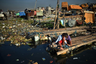 Children near their homes on Manila Bay in the Philippines, where authorities have been relocating people from coastal slums.
